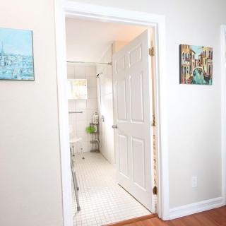 A view through a doorway into a bright and clean bathroom with wall art.