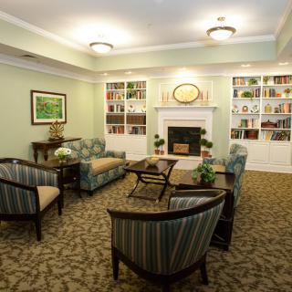 A cozy living room with comfortable seating, bookshelves, and a fireplace.