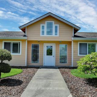 A well-maintained small house with a neat front yard and clear blue skies.