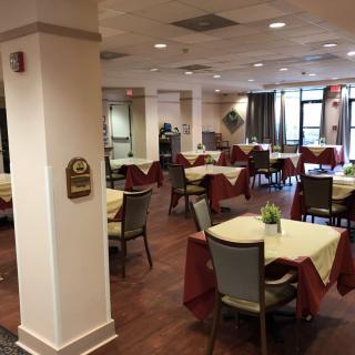 An empty dining room with neatly arranged tables and chairs.