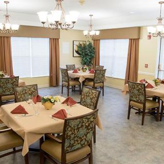 A well-decorated dining room with neatly set tables and elegant lighting.