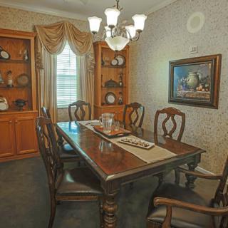 A classic dining room with a wooden table, chairs, and a chandelier.