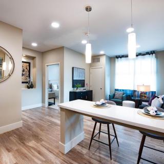 A modern open-concept kitchen and living room with an island counter and bar stools.