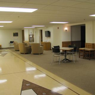 A spacious lounge area featuring comfortable seating and tables.