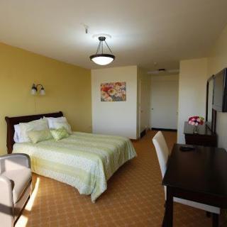 A cozy and modern bedroom with a comfortable bed, desk, and seating area.