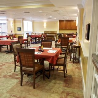 An empty dining room with neatly arranged tables and chairs.