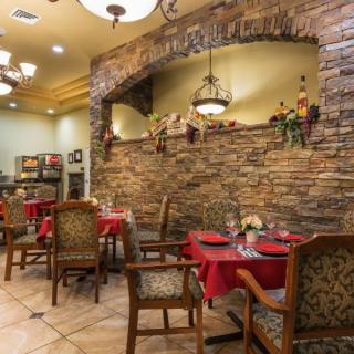 A cozy restaurant interior with brick walls and elegantly set tables.