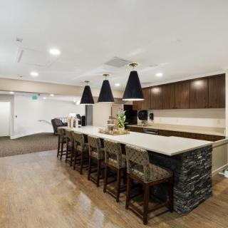 A modern kitchen with a bar counter and pendant lighting.