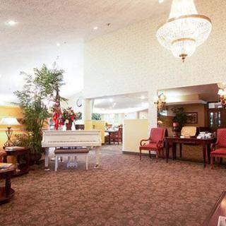 A spacious lobby with elegant decor, featuring a chandelier and seating area.