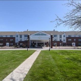 A large residential building with a well-maintained lawn and central entrance.