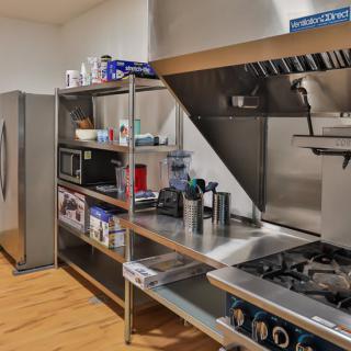 A clean and organized commercial kitchen space with stainless steel shelves and appliances.