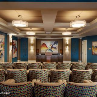 A modern conference room with theater-style seating and decorative artwork on the walls.