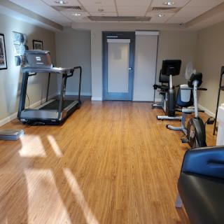 A well-equipped fitness room featuring a treadmill and stationary bike, designed for exercise and wellness.