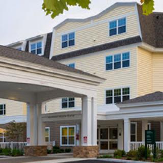 A welcoming residential building with a covered entrance and multiple windows.