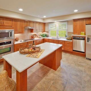 A modern kitchen featuring wooden cabinetry, sleek appliances, and a bright ambiance.
