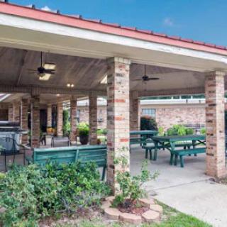 A cozy outdoor dining area featuring spacious seating and a charming brick structure.