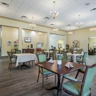 An elegantly decorated dining area with tables and chairs, featuring chandeliers and indoor decor.