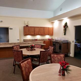 A cozy kitchen and dining area with round tables, chairs, and wall decorations.