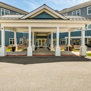 A grand building entrance with a covered porch and elegant columns.