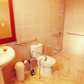 An accessible bathroom equipped with a toilet, sink, and grab bars for safety.