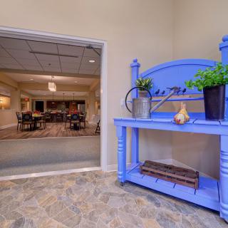 A welcoming lobby entrance featuring a blue decorative shelf with plants and ornaments.