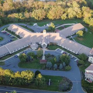 An aerial view of a residential building surrounded by lush greenery.