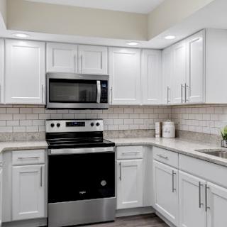 A modern kitchen featuring sleek white cabinets and stainless steel appliances, perfect for both functionality and style.