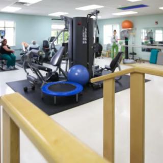 A well-equipped gym space featuring various fitness machines and rehabilitation equipment.