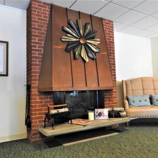 A cozy living room with a brick fireplace adorned with decorative artwork.