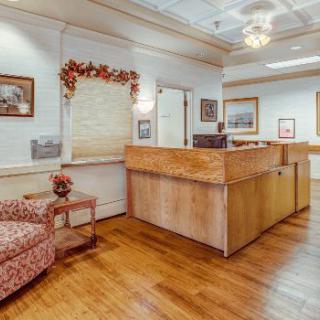 A welcoming reception area with a wooden desk and comfortable seating.
