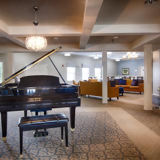 A spacious lounge with a grand piano and comfortable seating areas.
