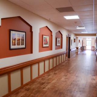 A well-lit hallway featuring framed photographs and a wooden floor, enhancing the inviting decor.