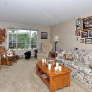 Cozy living room with a floral sofa, coffee table, and large window.