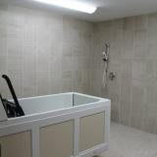 A modern bathroom with a sleek bathtub and tiled walls.