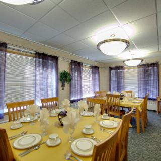 A well-set dining room with elegant tableware and warm lighting.