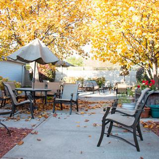 A peaceful patio area decorated with autumn leaves and outdoor furniture, perfect for enjoying a crisp fall day.