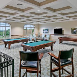 A spacious game room featuring pool tables and comfortable seating.