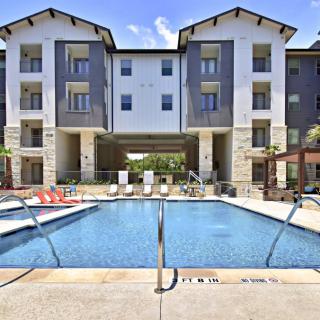 A modern apartment building featuring an outdoor swimming pool.
