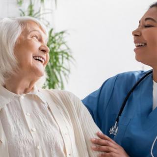 A nurse shares a joyful moment with an elderly woman, highlighting compassionate care.