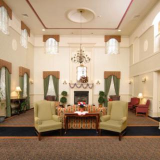 A spacious living room featuring elegant furniture, a central fireplace, and a chandelier.