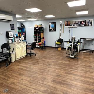 A well-equipped physical therapy clinic featuring exercise equipment and a comfortable waiting area.