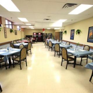 An empty restaurant dining area with neatly arranged tables and chairs.