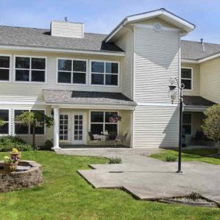 A two-story residential building with large windows and a well-maintained lawn.