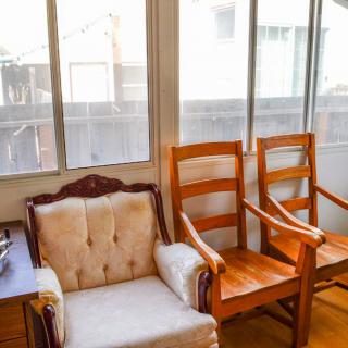 A cozy room with wooden chairs and a cushioned armchair by the window.