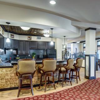 A cozy kitchen bar area with elegant seating and warm lighting.