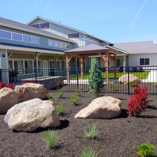 A landscaped garden with large rocks in front of a modern house.