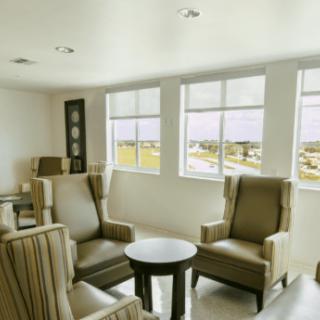 A modern living room with comfortable chairs and a small table by the window.