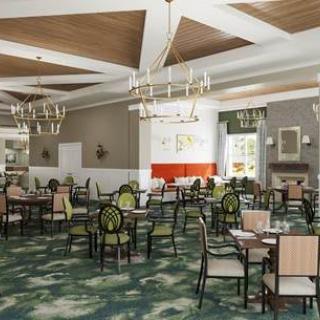 An elegantly furnished dining room with chandeliers, tables, and chairs.