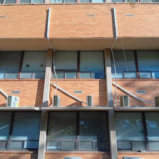 A close-up view of a modern brick building showcasing its balconies and large windows.