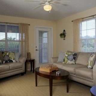 A cozy living room with two sofas and a coffee table featuring a chess set.